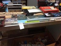 Wide view of the table with various tools and hardware items on top including the Snap-On hydraulic riveting tool, propane torch, vacuum gauge and some packaged items.