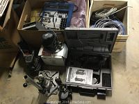 Photo showing the box of assorted wiring cables and a box with electronics items, along with the Porter Cable spiral saw and Craftsman sander.