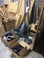 Photo showing hand air pump, coils of cables, and cardboard boxes with telephone handsets and wiring bundles.