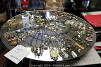 Overhead view of all necklaces arranged on round black display stand