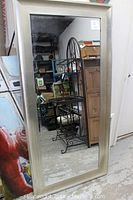 Full view of the large rectangular wall mirror showing silver frame and reflection of surrounding area.