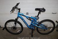 Full side view of blue Wicked Fugitive 24 mountain bike with 7 gears and full suspension.