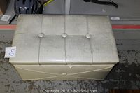 White storage ottoman closed, showing rectangular tufted top with buttons and white faux leather upholstery.