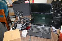 Lot showing Compaq laptop, Apple TV, various cables and accessories on a wooden table