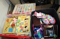 Photo showing wooden animal puzzles, bead containers, black container with kids items, and colorful new rain boots