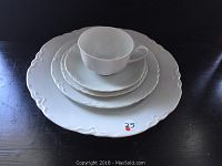 Single place setting stacked showing all pieces: 10-inch dinner plate, 8-inch dessert plate, 6-inch bread and butter plate, cup, and saucer.