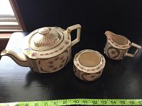 Sadler tea set consisting of teapot, creamer, and sugar bowl shown together with floral pattern and gold accents.