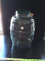 Front view of the large clear glass jar showing barrel-like ridges and a sticker with number 57 on the front.