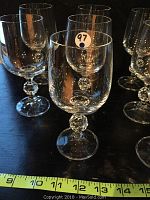 Close-up view of the crystal red wine glasses showing the faceted round stems and clear bowls with no visible damage.