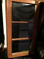 Front view of wooden window frame mirror with three sections and natural wood finish.