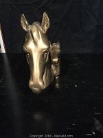 Front view of solid brass horse head book end showing detailed horse and foal faces.