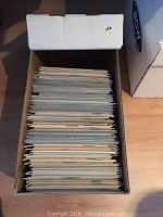 Top view of the box containing a stacked collection of comics, approximately 150 in quantity.
