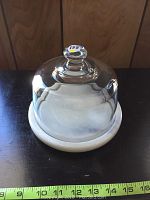 Glass dome placed on marble base with measuring tape showing about 17 inches diameter of base