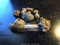 Diopside rock samples arranged on a dark surface with label visible. Various sizes and shapes of mineral specimens visible with rough crystal formations.