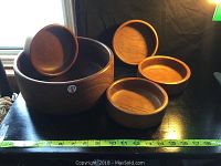 Photo showing one large and four smaller solid wood salad bowls with a tape measure indicating size approximately 10 inches for large bowl and 5.5 inches for small bowls
