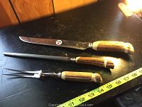Full set of three pieces displayed with measuring tape for scale, showing knife, sharpening steel, and carving fork with antler handles and stainless blades and tines