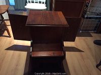 Front view of wooden table showing open side shelf and flat top surface.