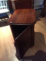 View showing top surface and open storage door revealing interior compartment