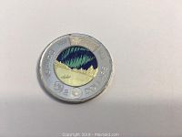 Reverse of the 2017 Canadian two-dollar coin showing Northern Lights design with glow in the dark feature.