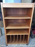 Front view of oak entertainment unit showing two open shelves and vertical dividers at the bottom.