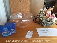 Overall lot contents on table: fairy fountain, glass bowl, two floating candles in packaging, paperwork.