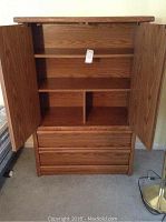 Full view of Palliser wooden armoire with both doors open showing interior shelves and two drawers below.
