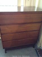 Front view of the wooden dresser showing four drawers and integrated handles