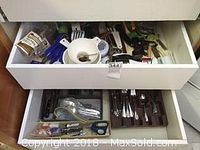 Drawer of assorted kitchen utensils and cutlery including forks, knives, and spoons.
