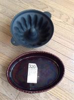 Top view of the cast iron Bundt pan and the oval serving dish placed side by side on a wooden floor.
