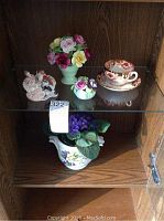 Photo of all five bone china and decorative items inside wooden display cabinet