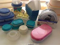 Close up of smaller Rubbermaid containers with blue and turquoise lids, pink lidded container, and popsicle molds, with boxed Anchor Hocking StowAway collapsible bowls.