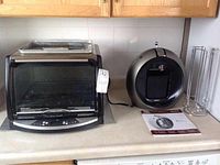 Black and Decker Horno Rapido toaster oven and Krups Nescafe Dolce Gusto coffee machine with pod rack on countertop