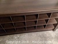 Front view of chocolate brown wooden bench with cubby storage compartments