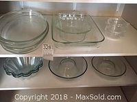 Wide shot showing all glass bowls and bakeware on open shelves, including round bowls, square and rectangular baking dishes, and smaller round bowls.