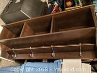 Wall unit showing full front view including two open rectangular compartments above and four coat hooks below.