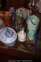 Full assortment of ceramic vases, bowls, and lamps on kitchen counter showing various animal and leaf designs.