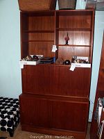 Full view of two-piece teak veneer cabinet and hutch furniture showing open shelving on top and closed lower cabinet doors