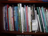 First photo of shelf with knitting and sock making books, including titles like Knitter's Stash, Knitting Nature, Scandinavian Knitting Designs, and others.