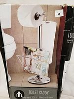 Photo of the toilet caddy in packaging showing its design and intended use in a bathroom setting next to a toilet.