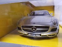 Close-up of the front of the silver Mercedes Benz SLS AMG remote control car showing AMG badge and car grille inside packaging.