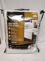 Front view of Beautyrest Hotel Luxury mattress pad in original plastic packaging showing brand, product name, and size as Double.