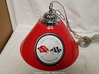 Red Chevrolet Corvette ceiling light fixture with chrome hanging chain and mount.