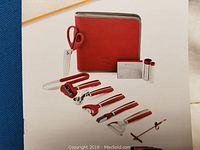 Photo of the assembled garnishing tools laid out in front of the red case.