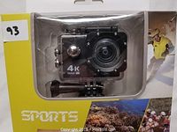Front view of the sports camera securely housed inside a clear waterproof case mounted on black mounting hardware, showing '4K 16M' printed on the camera body.