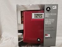 Box photo showing scale in red with digital display and branding.
