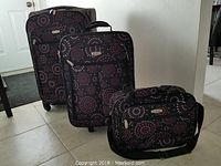 Three luggage pieces set on tile floor showing full set and pattern.