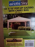 Close-up of product packaging showing brand Arctic Sky and photo of the beige pop-up gazebo set up outside along with carry bag image.