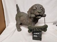 Front angle of the Hometrends dog statue holding a welcome sign with tag.