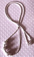 Full view of the sterling silver necklace laid out on a textured background, showing length and beaded section.