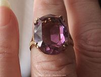 Front view of the oval amethyst stone in claw setting on the ring finger.